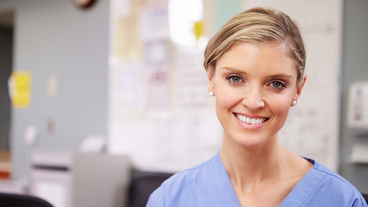 a weight loss physician in teh weight loss clinic wearing blue scrubs smiling