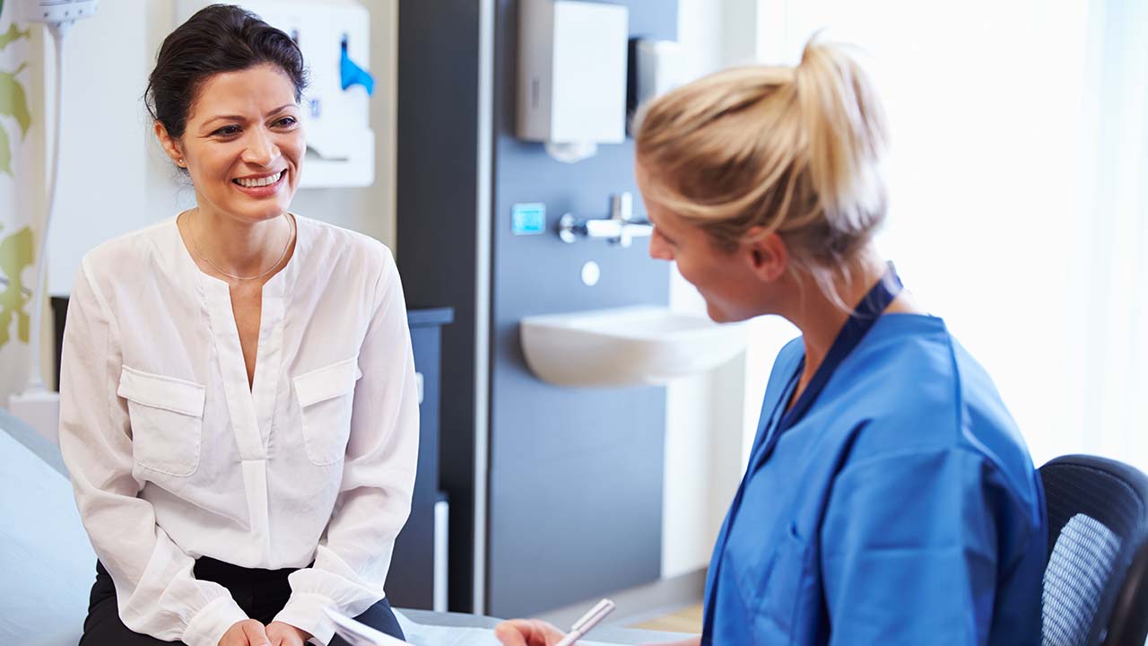 client talks to the doctor in the exam room